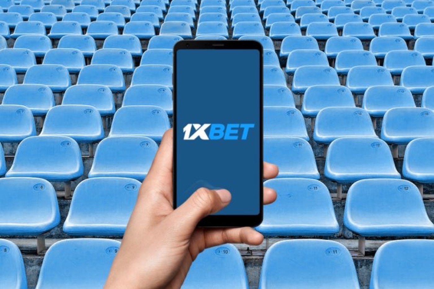 Phone showing the 1xBet app at a sports venue
